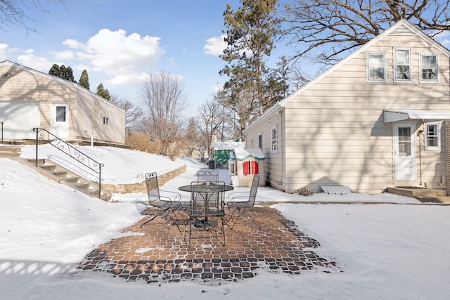 yard layered in snow featuring a patio area