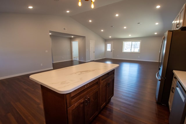 kitchen with baseboards, appliances with stainless steel finishes, open floor plan, dark wood-type flooring, and vaulted ceiling