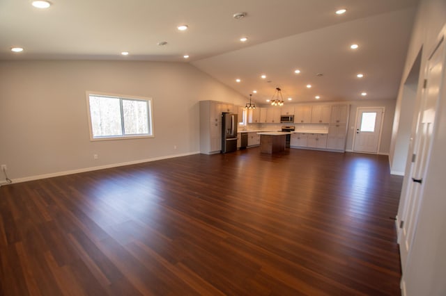 unfurnished living room featuring dark wood-style floors, vaulted ceiling, baseboards, and recessed lighting