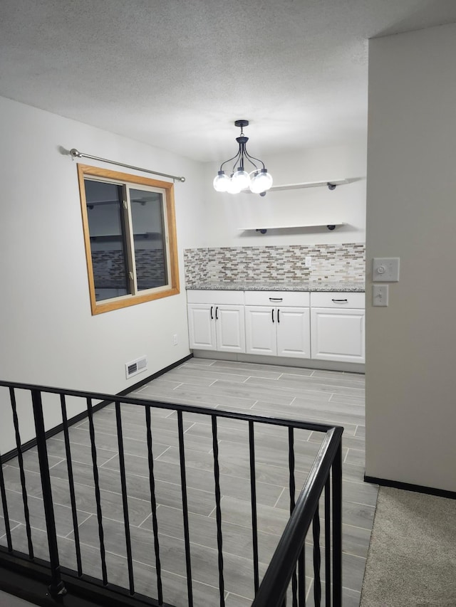 interior space featuring an inviting chandelier and a textured ceiling