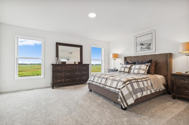 carpeted bedroom featuring multiple windows