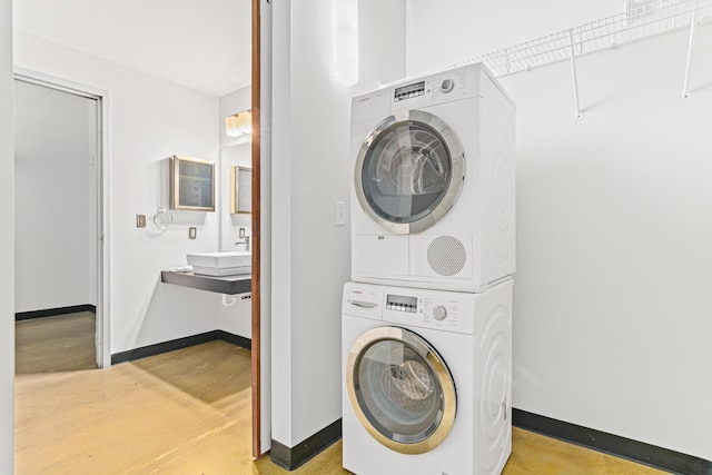 washroom featuring stacked washer and dryer and sink