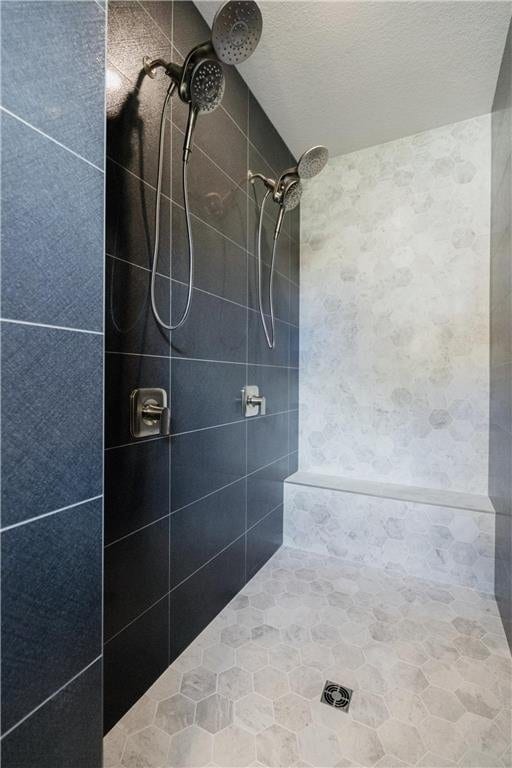 bathroom with a tile shower and a textured ceiling