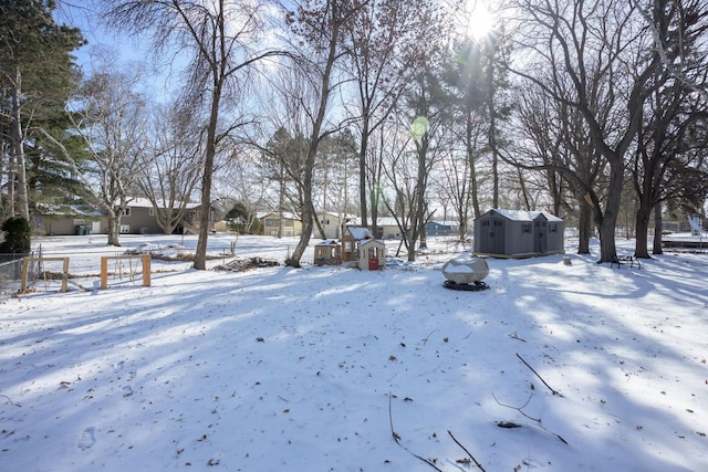 yard covered in snow featuring a storage unit