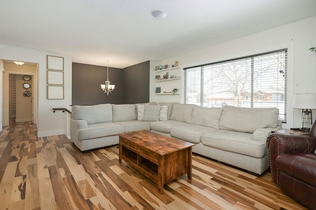 living room with an inviting chandelier and light hardwood / wood-style floors