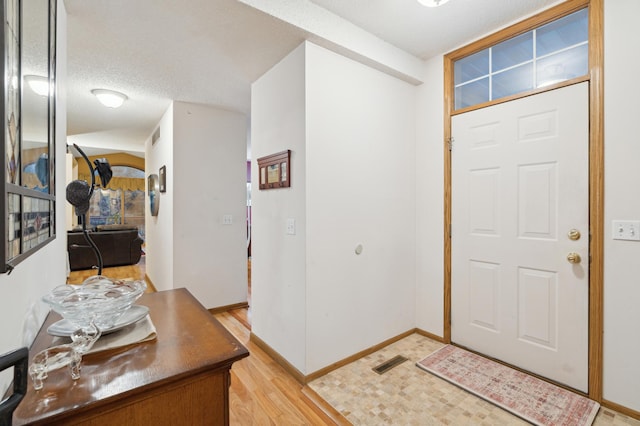 foyer featuring a textured ceiling and light wood-type flooring