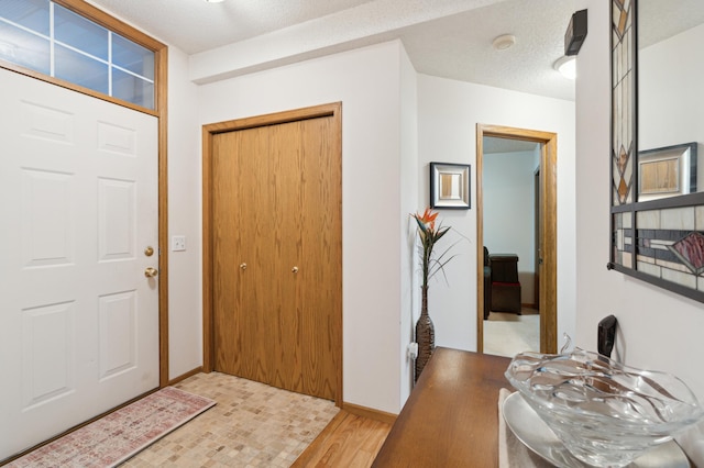 entrance foyer with light hardwood / wood-style floors and a textured ceiling