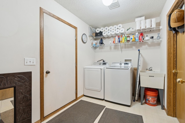 laundry area featuring a textured ceiling and washing machine and clothes dryer