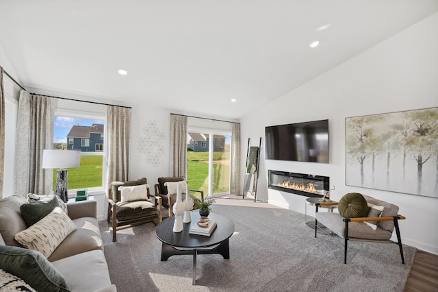 living room with hardwood / wood-style floors, plenty of natural light, and vaulted ceiling