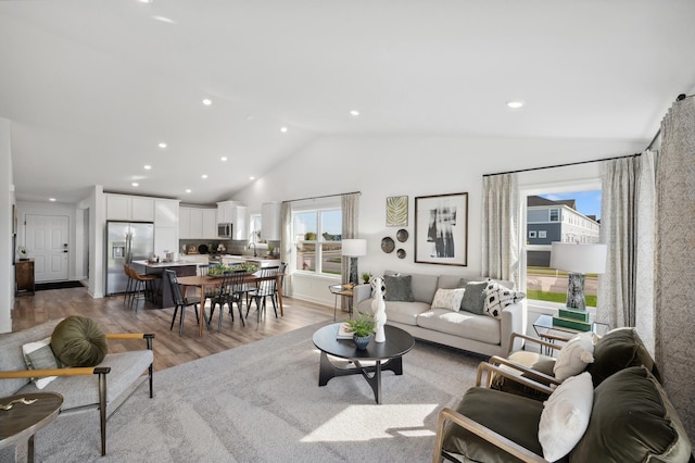 living room with vaulted ceiling and light hardwood / wood-style flooring