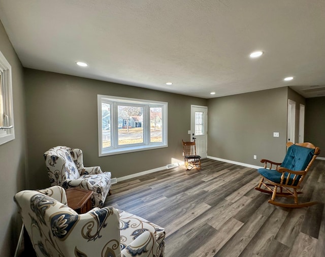 living area featuring hardwood / wood-style flooring and a healthy amount of sunlight