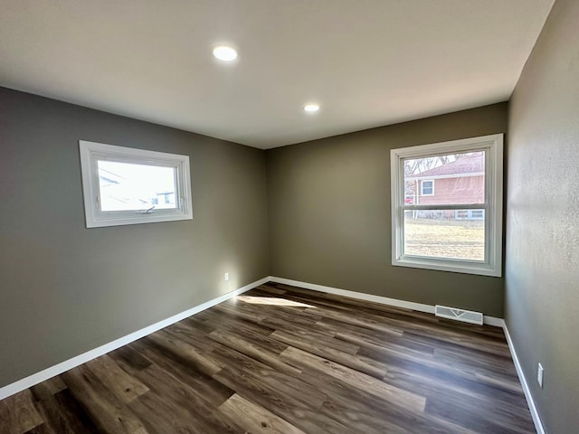 912 Oakley St, Luverne, MN 56156 - empty room with dark hardwood / wood-style flooring and plenty of natural light