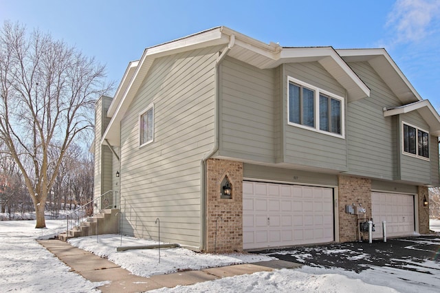 snow covered property with a garage