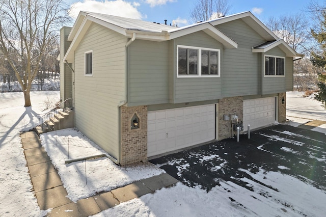 view of snow covered exterior with a garage