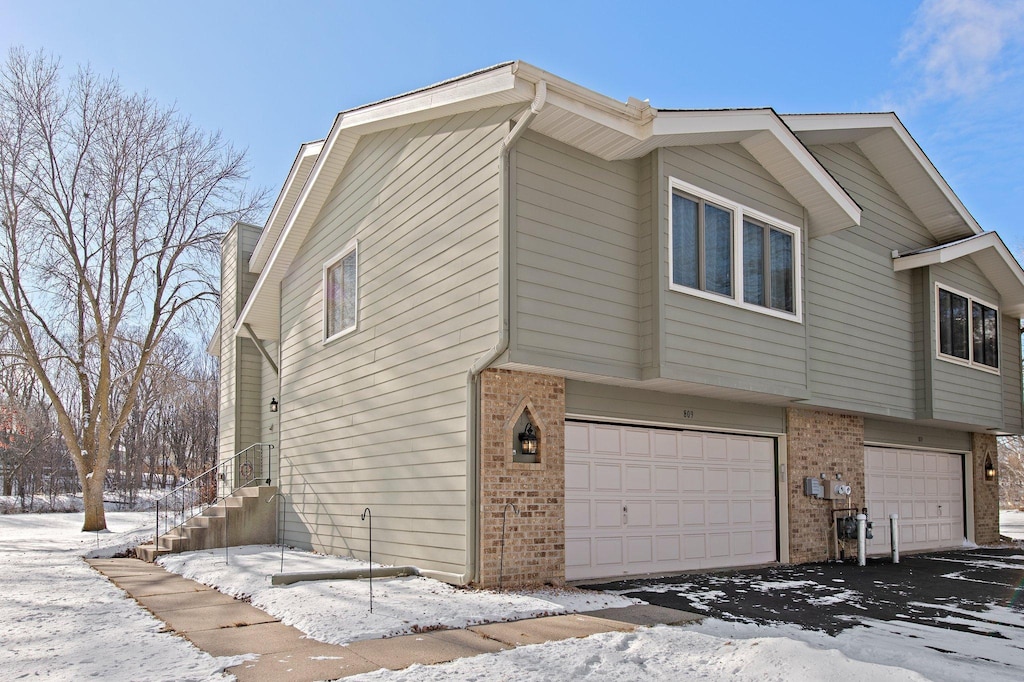 view of snowy exterior with a garage