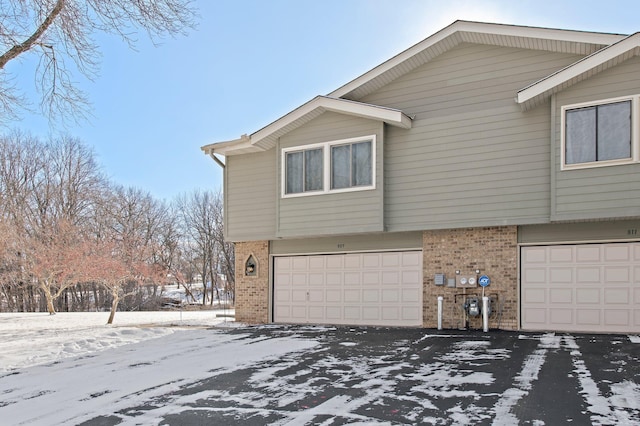 view of snowy exterior featuring a garage