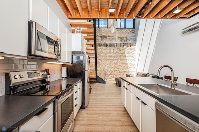 kitchen featuring tasteful backsplash, sink, stainless steel appliances, and white cabinets