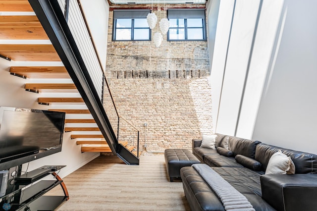 living room with brick wall and hardwood / wood-style floors