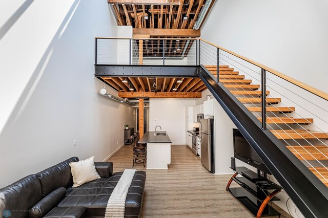 staircase with sink and hardwood / wood-style flooring