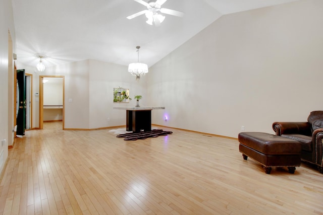 unfurnished room featuring light hardwood / wood-style flooring, ceiling fan with notable chandelier, and lofted ceiling