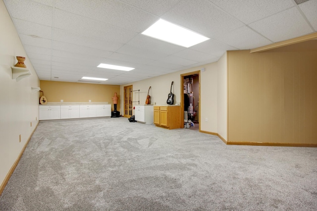 unfurnished room with light carpet, gas water heater, and a drop ceiling