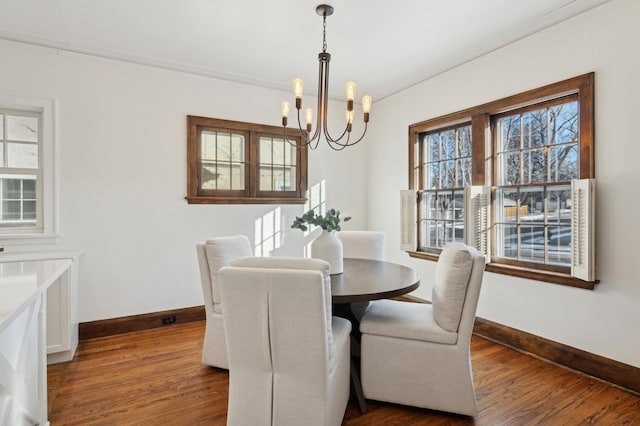 dining area with dark hardwood / wood-style flooring, crown molding, and a chandelier