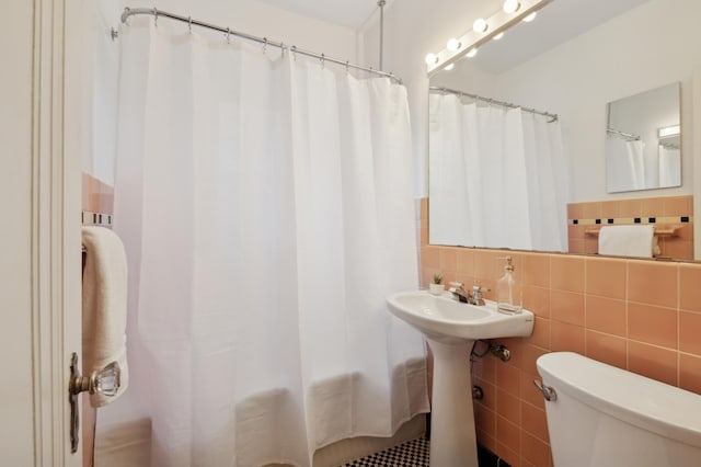 bathroom featuring tile walls, backsplash, a shower with shower curtain, and toilet