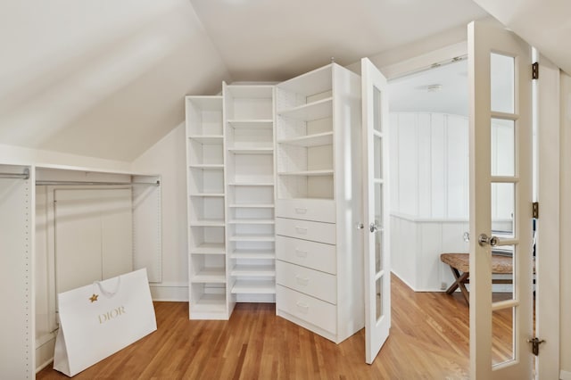 walk in closet with vaulted ceiling and wood-type flooring