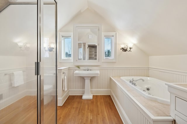 bathroom with hardwood / wood-style flooring, vaulted ceiling, and shower with separate bathtub