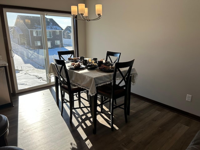 dining space with hardwood / wood-style floors and a notable chandelier