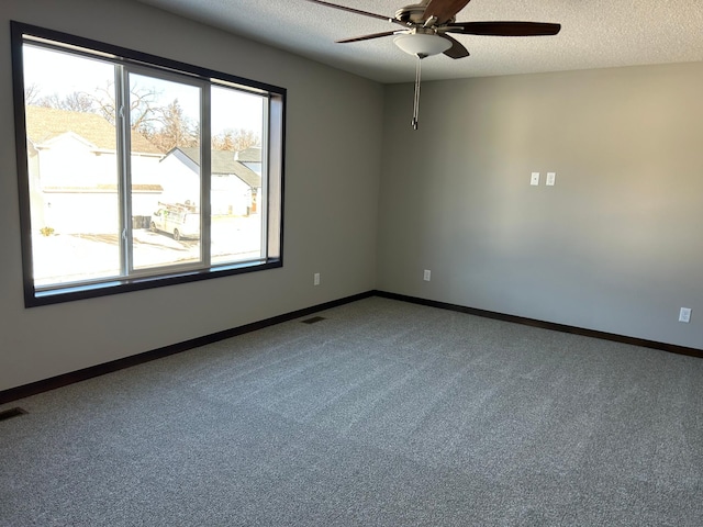 carpeted empty room featuring ceiling fan and a textured ceiling