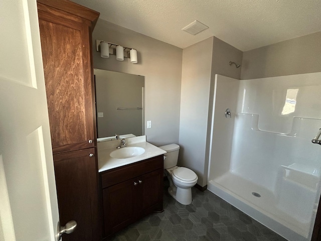 bathroom with walk in shower, vanity, toilet, and a textured ceiling