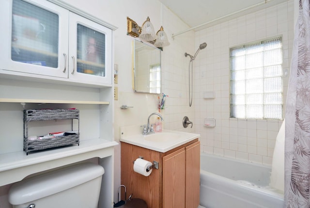 full bathroom featuring shower / bath combo, a healthy amount of sunlight, toilet, and vanity