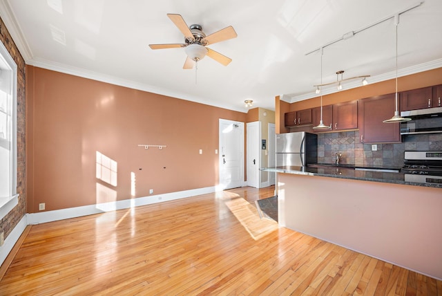 kitchen with track lighting, light hardwood / wood-style flooring, tasteful backsplash, decorative light fixtures, and stainless steel appliances