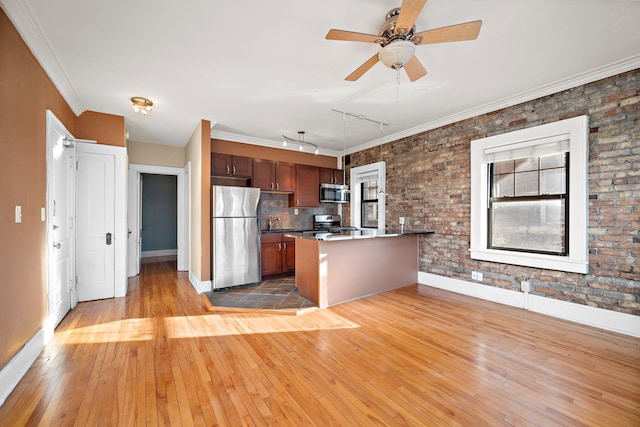 kitchen featuring ceiling fan, hanging light fixtures, stainless steel appliances, track lighting, and decorative backsplash