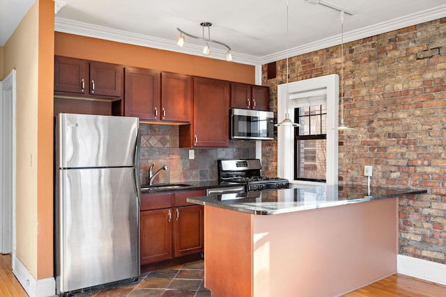 kitchen featuring appliances with stainless steel finishes, ornamental molding, dark stone counters, and sink