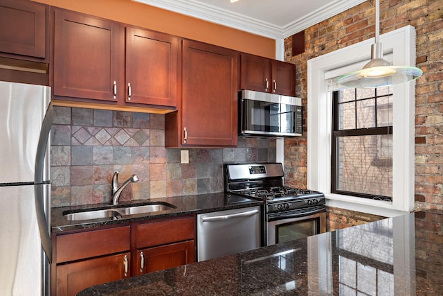 kitchen featuring sink, hanging light fixtures, backsplash, dark stone counters, and appliances with stainless steel finishes