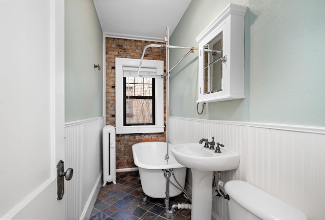 bathroom featuring a bath, toilet, and radiator