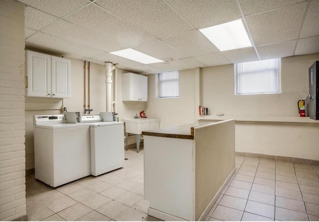 laundry area with cabinets, sink, light tile patterned floors, and washer and dryer