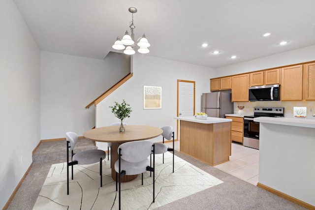 kitchen featuring light carpet, decorative light fixtures, a kitchen island, stainless steel appliances, and a chandelier