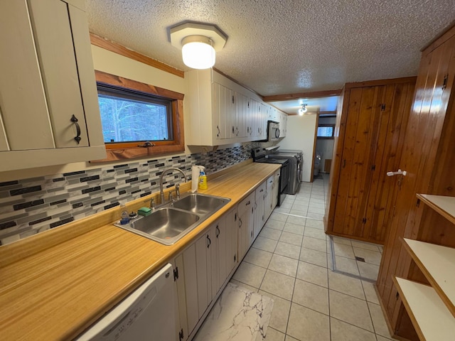 kitchen with stove, white dishwasher, sink, a textured ceiling, and tasteful backsplash