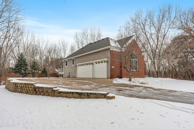 view of snow covered exterior with a garage