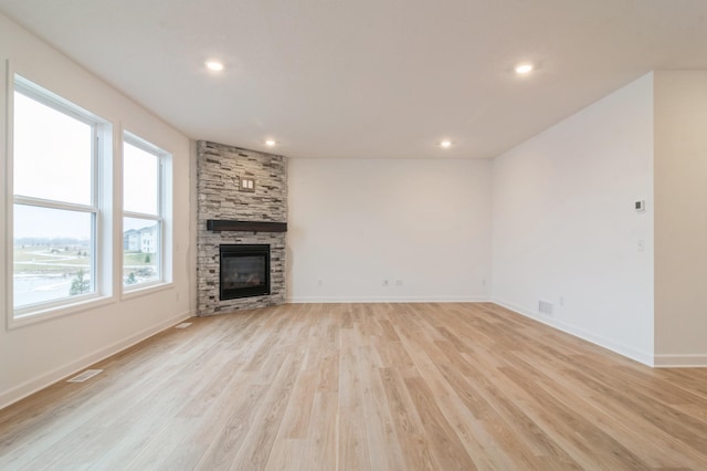 unfurnished living room featuring light wood-type flooring and a fireplace