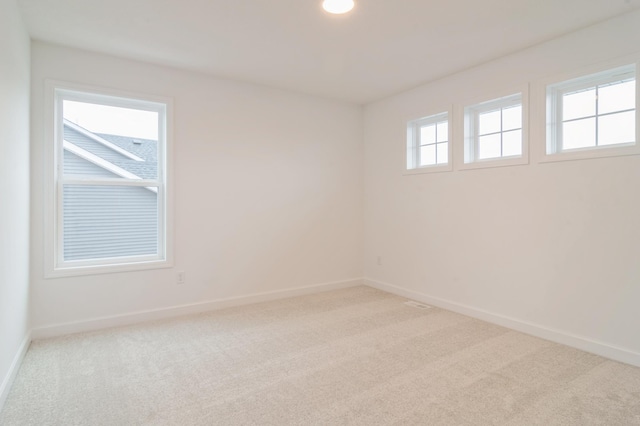 unfurnished room featuring light colored carpet