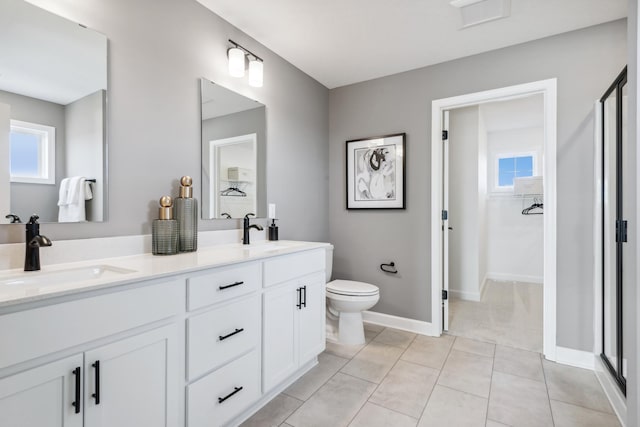 bathroom featuring tile patterned flooring, plenty of natural light, vanity, and toilet