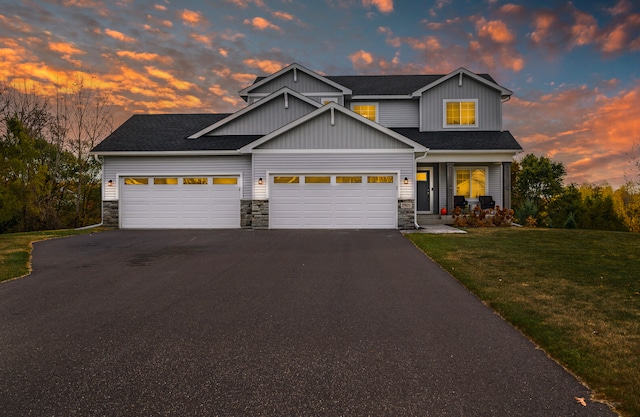 craftsman house featuring a garage and a lawn