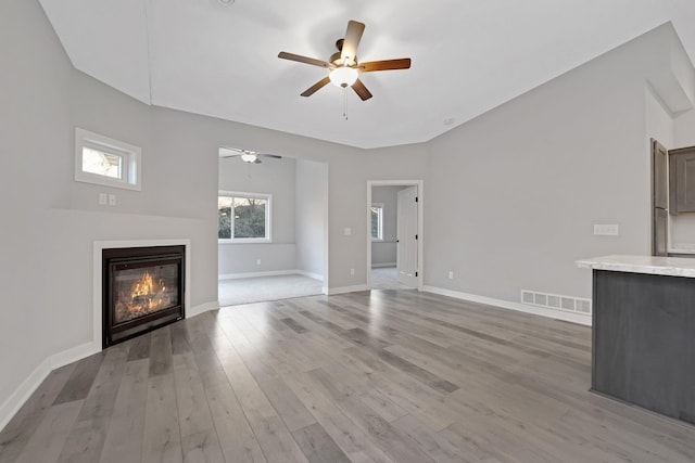 unfurnished living room with ceiling fan and light wood-type flooring