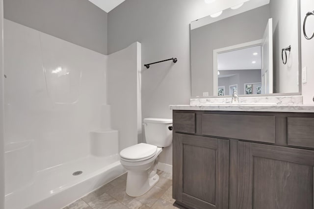 bathroom featuring a shower, vanity, and toilet