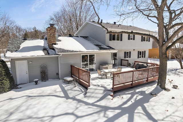 snow covered house with a wooden deck