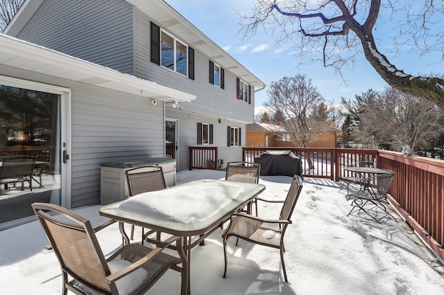 snow covered patio with a deck, area for grilling, and outdoor dining area